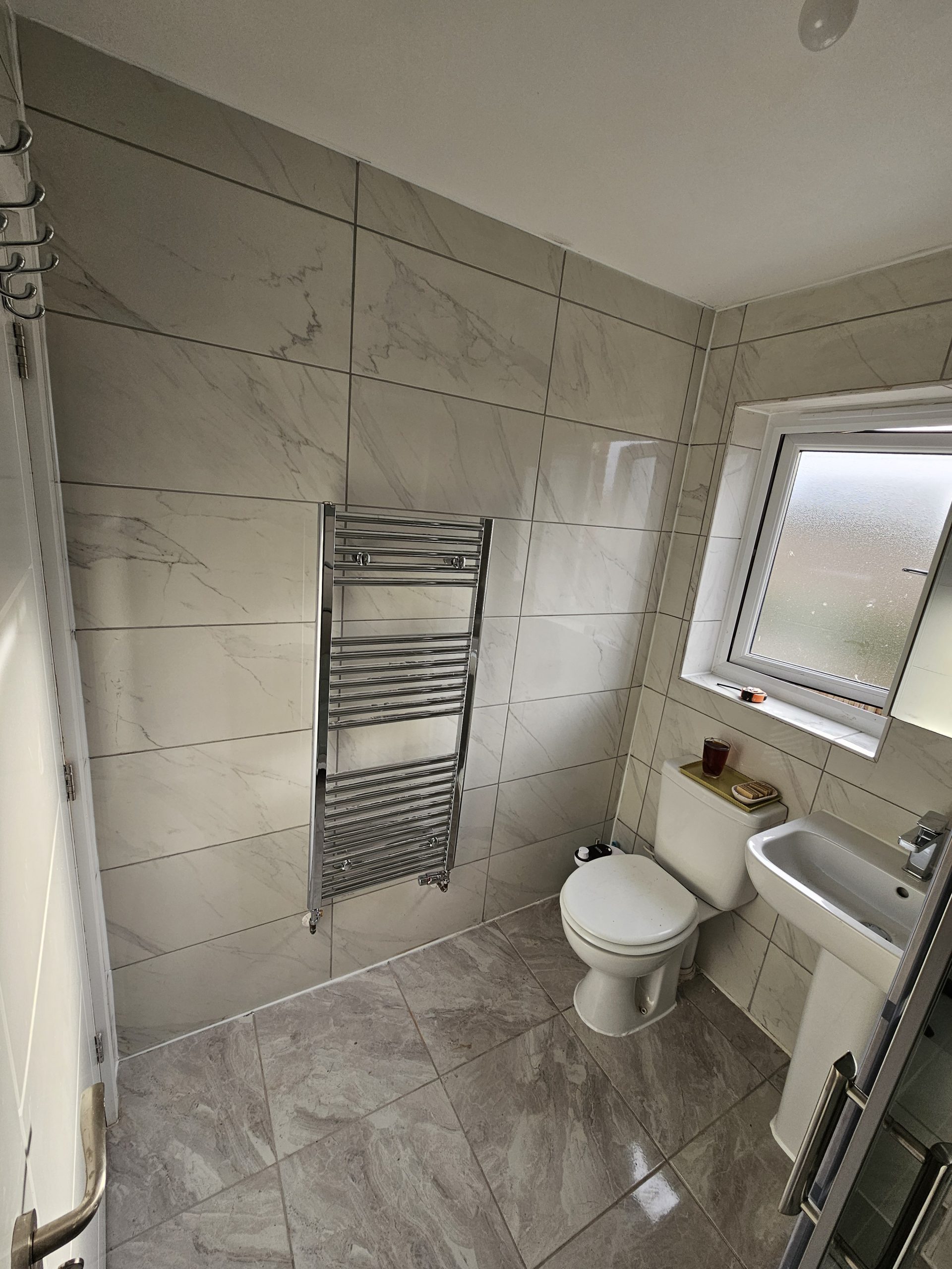 Photo of tile flooring in a bathroom after installation by Builder Base in Newport, South Wales